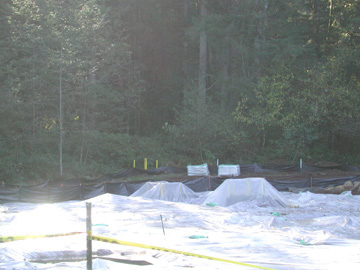 Camp BonnevilleLandfillFourcoatedinplastic Landfill Four is coated in plastic to prevent erosion and movement of the pollution from rain. The yellow posts in the background mark a test well that is used to monitor ammonium perchlorate levels in the groundwater.